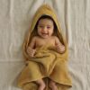 Cape de bain bébé vert olive en coton gaufré nid d’abeille accompagnée de son gant de toilette assorti, douce et absorbante pour la sortie du bain.